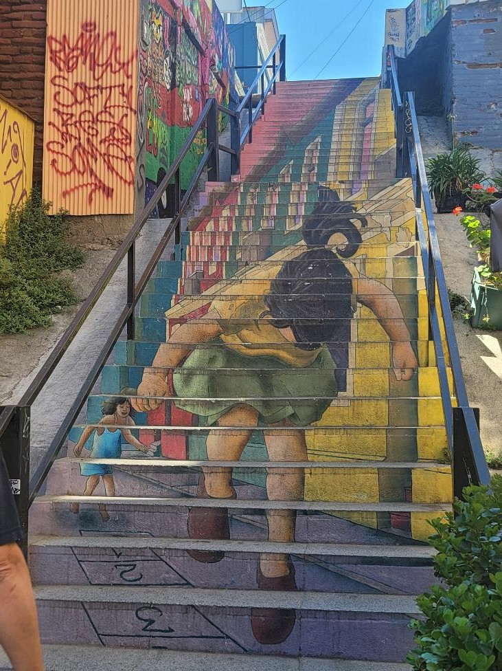 Colorful painted staircase in Valparaíso, Chile featuring a mural of a child climbing the steps